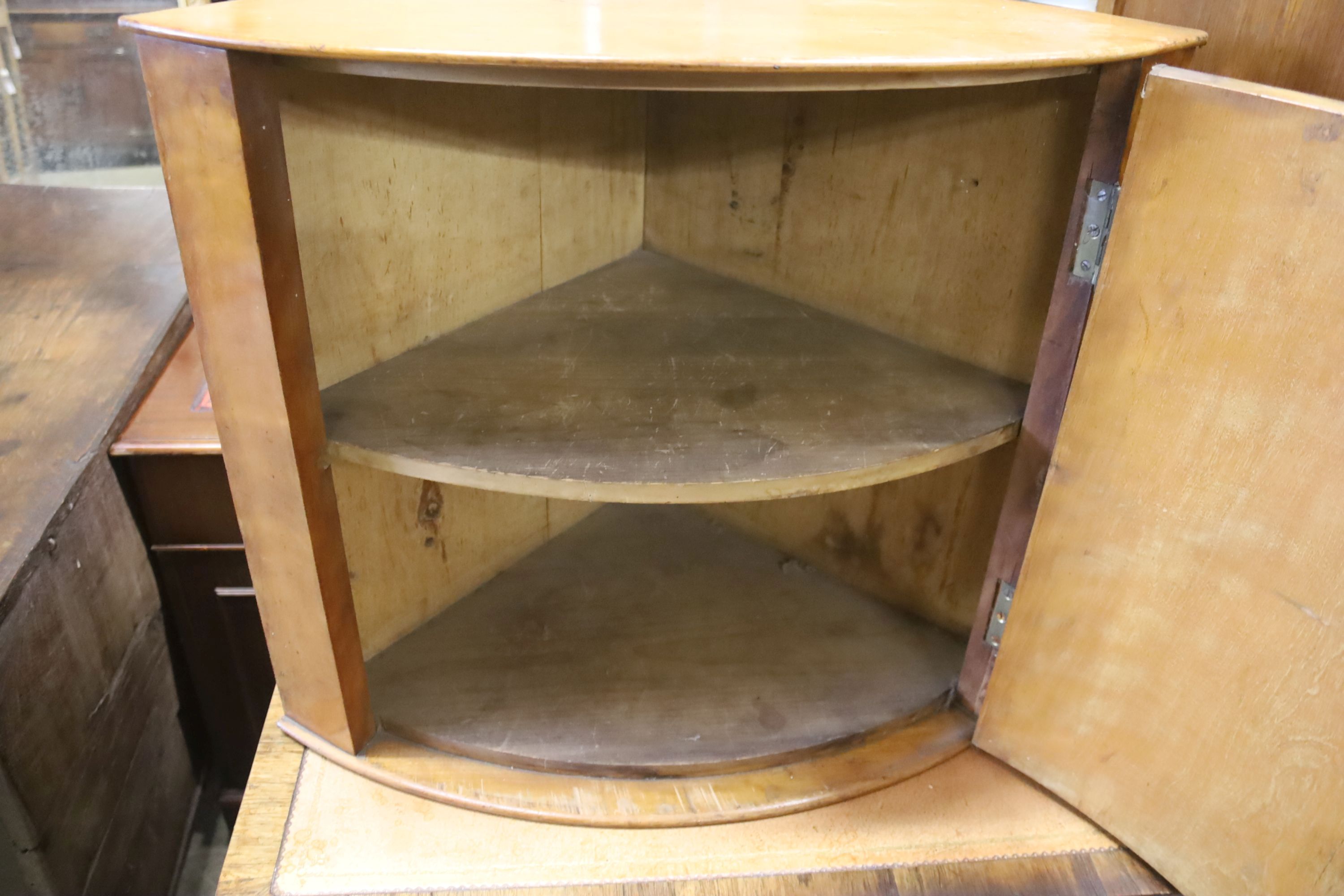 A Victorian satin birch bow front hanging corner cabinet, width 64cm, depth 43cm, height 56cm